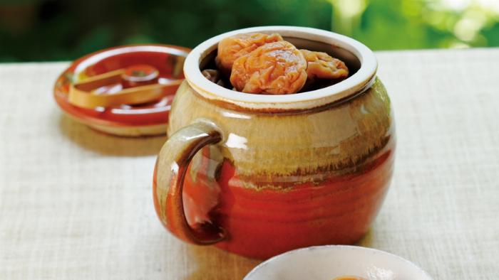 手作り梅酒の基本材料である青梅と氷砂糖とホワイトリカーがガラス瓶の横に並べられている様子