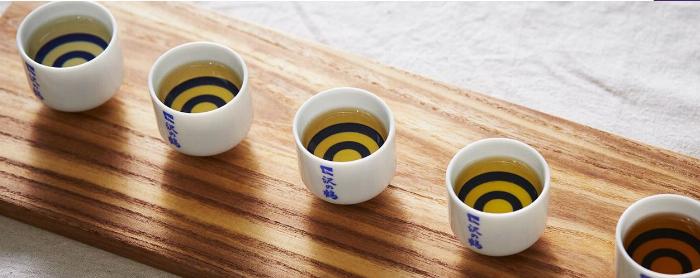 ウイスキーで作った琥珀色の梅酒とグラス、熟成された深い味わいを表現