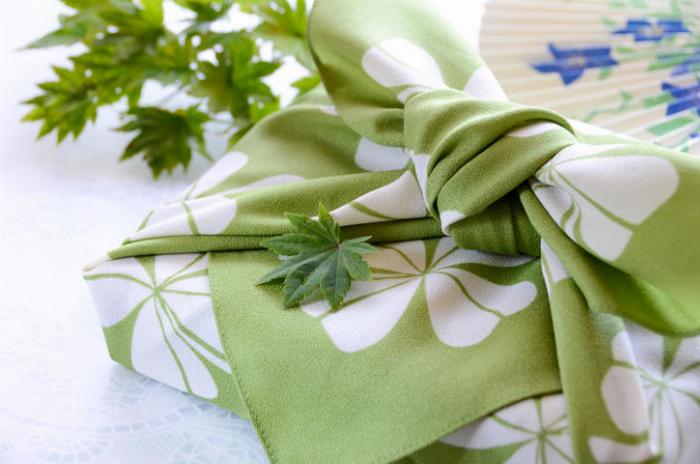 グラスに注がれたやさしい梅酒と背景に置かれた青梅の実